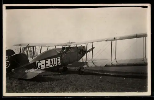 AK Britisches Doppeldecker-Flugzeug mit Kennung G-EAUE auf dem Flugfeld