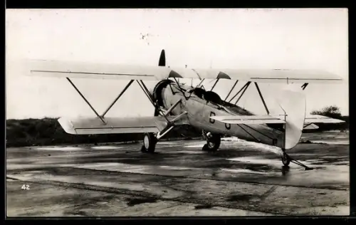 AK Doppeldecker-Flugzeug mit Bremsklötzen auf der Landebahn