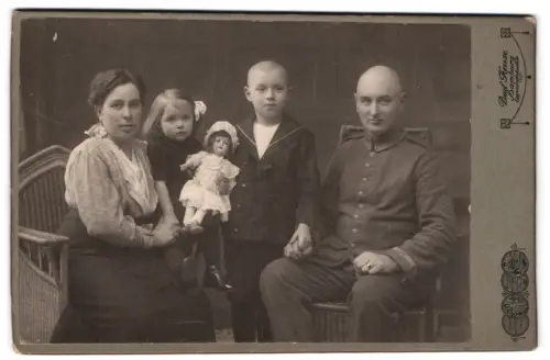 Fotografie Paul Kruse, Hamburg, Eppendorferlandstrasse 102, Familienportrait mit Puppe und Vater in Uffz. Uniform