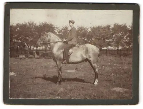 Fotografie Junger Reiter auf einem Pferd im Freien