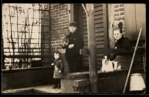 Foto-AK Familie mit Hund und Teddy vor einem Haus