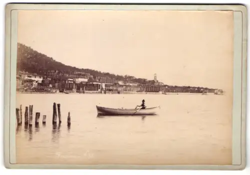 Fotografie Augusto Baroni, Riva Trentino, Ansicht Fasano, Boot auf See vor der Küstenstadt