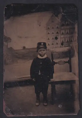 Fotografie Ferrotypie unbekannter Fotograf und Ort, Kind in Uniform vor Gebäudekulisse