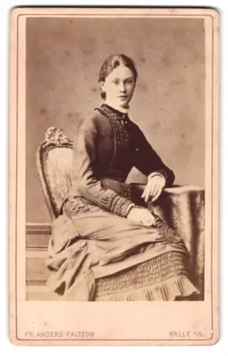 Fotografie Fr. Anders-Paltzow, Halle a. S., Grosse Ulrich Strasse 35, Dame im Kleid am Tisch