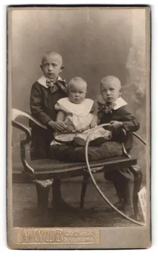 Fotografie Albert Wickfelder, Essen a.d. Ruhr, Schützenbahn 4, Kinder auf einem Stuhl mit Reifen