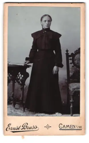 Fotografie Ernst Brass, Camen i. W., Bahnhofstrasse, Dame im dunklen Kleid neben Tisch