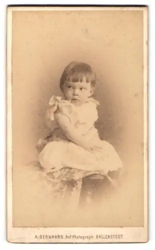 Fotografie A. Bernhard, Ballenstedt, Sitzendes Kleinkind im weissen Kleid