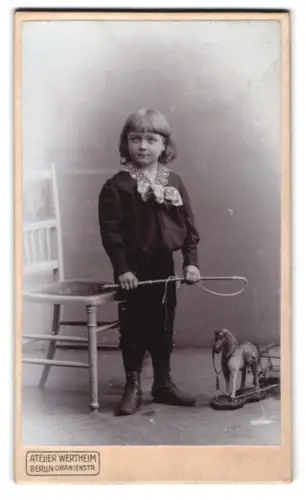 Fotografie Atelier Wertheim, Berlin, Oranienstr., Kind mit Spielzeugpferd und Reitgerte