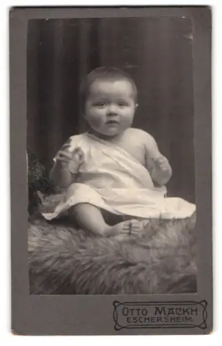 Fotografie Otto Mackh, Eschersheim, sitzendes Kleinkind in Tuch gehüllt