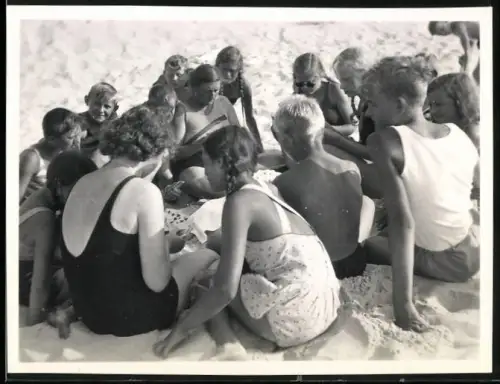 Fotografie Bademode, Frauen und Kinder in Badebekleidung beim Kartenspiel am Strand
