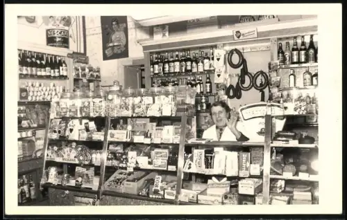 Fotografie Verkaufsdame hinter Tresen im Lebensmittelladen, Produkte von Nescafe, Tobler, Sarotti, Cadbury uvm.