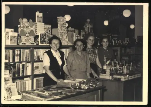 Fotografie Verkaufsdamen einer Buchhandlung hinter Verkaufstresen stehend
