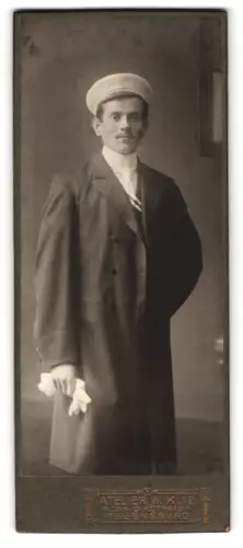 Fotografie Atelier W. Klie, Regensburg, Eleganter Student mit Tellermütze, Couleur und Handschuhen