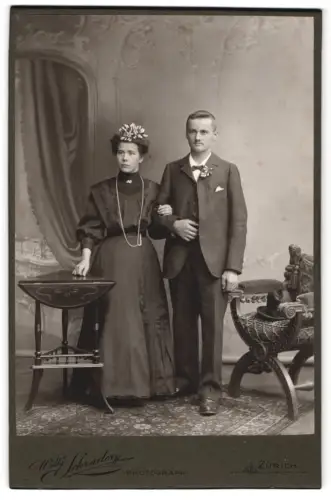 Fotografie Willy Schrader, Zürich, Schützengasse 23, Elegantes Brautpaar Arm in Arm im Studio