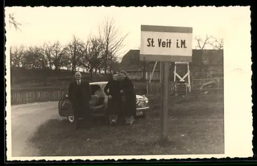 Foto-AK St. Veit i. M., Ortsschild mit Personen und Auto