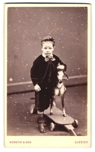 Fotografie Webster & Son, Chester, 19 Bridge St. Row, Kleiner Junge mit Spielzeugpferd auf Rädern