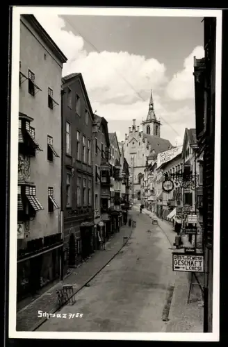 AK Schwaz /Tirol, Strasse mit Geschäften und Kirchturm