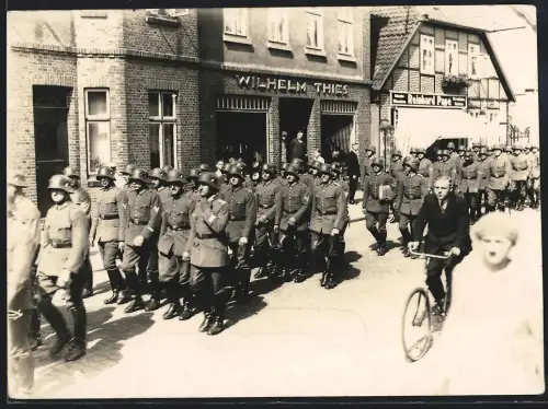 Fotografie Robert Hannemann, Soltau, Ansicht Soltau, Soldaten der Reichswehr im marsch vor Laden von Wilhelm Thies 1929