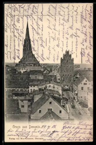 AK Demmin, Strassenpartie mit Tor, Im Hintergrund Kirche