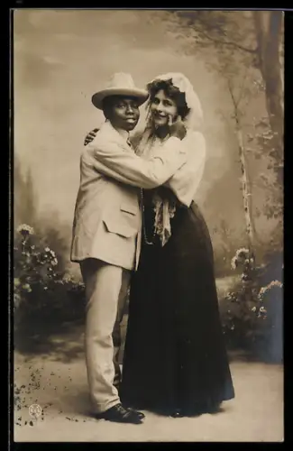 Foto-AK Afrikanischer Herr mit einer Dame im Arm vor Studiokulisse