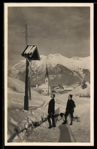Foto-AK Innsbruck, Vill, Winteransicht mit Kirche und Männern mit Schlitten