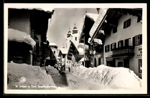 AK St. Johann in Tirol, Spadbachstrasse mit Kirche im Winter mit Schneemassen