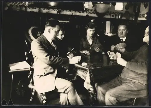 Fotografie Familie beim Kartenspiel in einer Gaststätte
