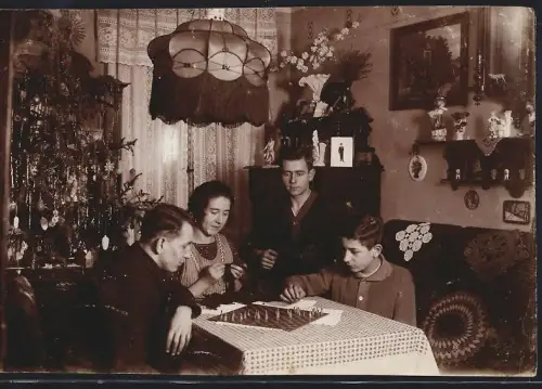 Fotografie Spieleabend zu Weihnachten, Familie spielt Brettspiel - Gesellschaftsspiel, Weihnachtsbaum, XMAS