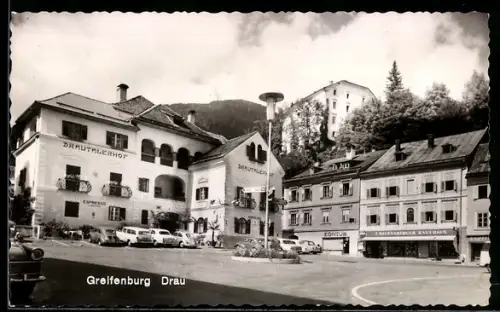 AK Greifenburg /Drau, Platz mit Gasthof Drautalerhof, Kaufhaus und Brunnen
