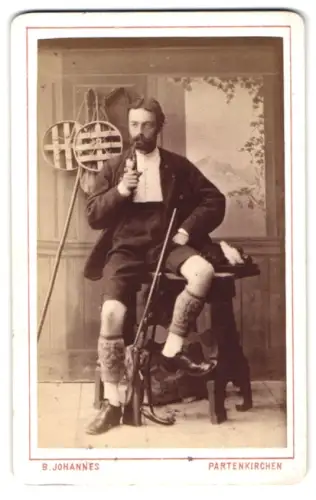 Fotografie B. Johannes, Partenkirchen, Portrait eines Schützen mit Gewehr und Pfeife