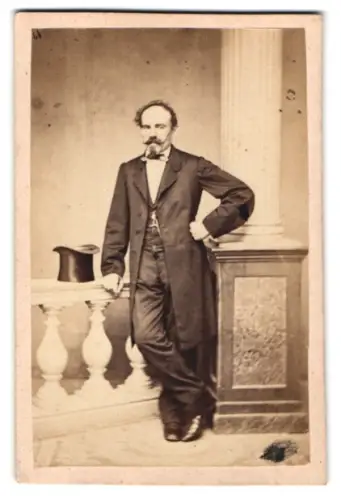 Fotografie unbekannter Fotograf und Ort, Mann mit einem Zylinder steht neben einer Säule