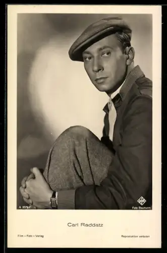AK Schauspieler Carl Raddatz, seitliches Portrait mit angewinkeltem Bein, mit Mütze und Uhr