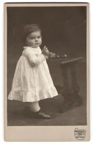 Fotografie H. Widensohler, Stuttgart, Königstrasse 21, Porträt eines kleinen Kindes am Tisch