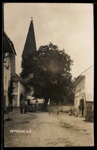 AK Oftering /O.Ö., Strasse mit Kirche und grossem Baum