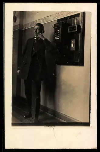 Foto-AK Mann mit Telefon in der Hand in einem Zimmer