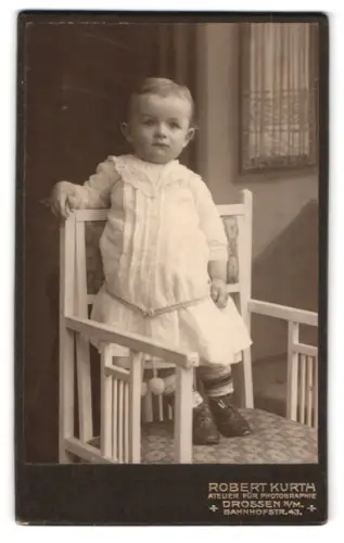 Fotografie Robert Kurth, Drossen, Bahnhofstrasse 43, Kind auf Stuhl in weissem Kleid
