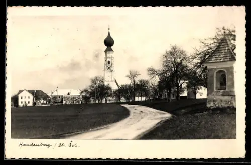 AK Handenberg /Ob. Öst., Geschwungene Strasse mit Kirchturm-Panorama und Bildstock