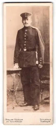 Fotografie Atelier Hüseler, Schleswig, Stadtweg 34, Soldat in Uniform mit Schirmmütze und Bajonett