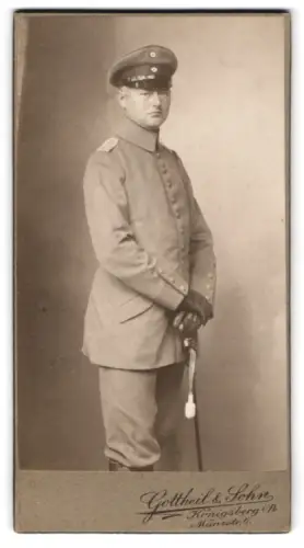 Fotografie Gottheil & Sohn, Königsberg i. Pr., Münzstr. 6, Offizier in Feldgrau Uniform mit Schirmmütze und Säbel, 1915