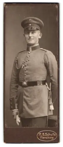 Fotografie M. B. Schultz, Flensburg, Unteroffizier in Uniform mit Schützenschnur 1. Stufe, Schirmmütze und Bajonett
