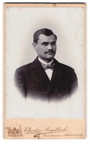 Fotografie Charles Angelbeck, Cuxhaven, Portrait stattlicher Herr im Anzug mit Fliege und Schnurrbart