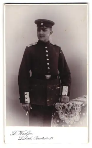 Fotografie Th. Woelfer, Lübeck, Breitestr. 35, Soldat vom Infanterie-Regiment Lübeck Nr. 162 in Uniform mit Schirmmütze