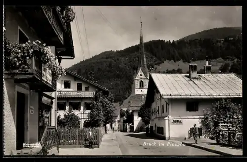 AK Bruck im Pinzgau, Strasse mit Kirche und Bergpanorama
