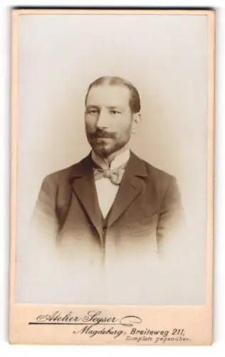 Fotografie Atelier Seyser, Magdeburg, Portrait Herr mit Bart in Anzug mit Fliege