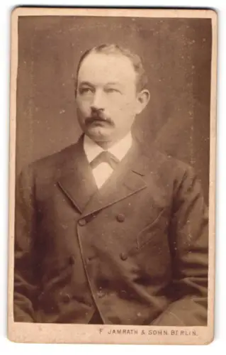 Fotografie F. Jamrath, Berlin, Herr mittleren Alters mit zurückgehendem Haar und Schnauzer