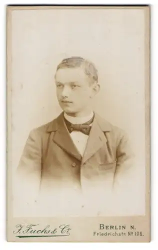 Fotografie J. Fuchs, Berlin-N, Portrait halbwüchsiger Knabe in Anzug mit Fliege