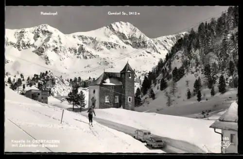 AK Obertauern, Kapelle mit Zehnerkar-Seilbahn und Gebirgspanorama, Skiläufer, Strasse