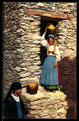 AK Aritzo, Costumi Sardi, Donna con brocca d`acqua e uomo in costume tradizionale sardo davanti a un muro di pietra