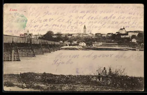AK Enns, Ufer mit Holzbrücke und Stadtpanorama mit Kirche