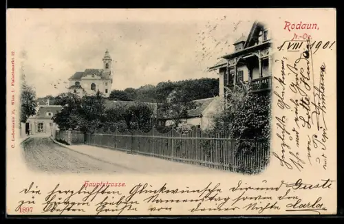 AK Rodaun, Hauptstrasse mit Häuserfront und Kirche im Hintergrund